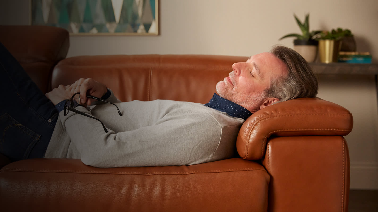 Man relaxing on brown leather sofa