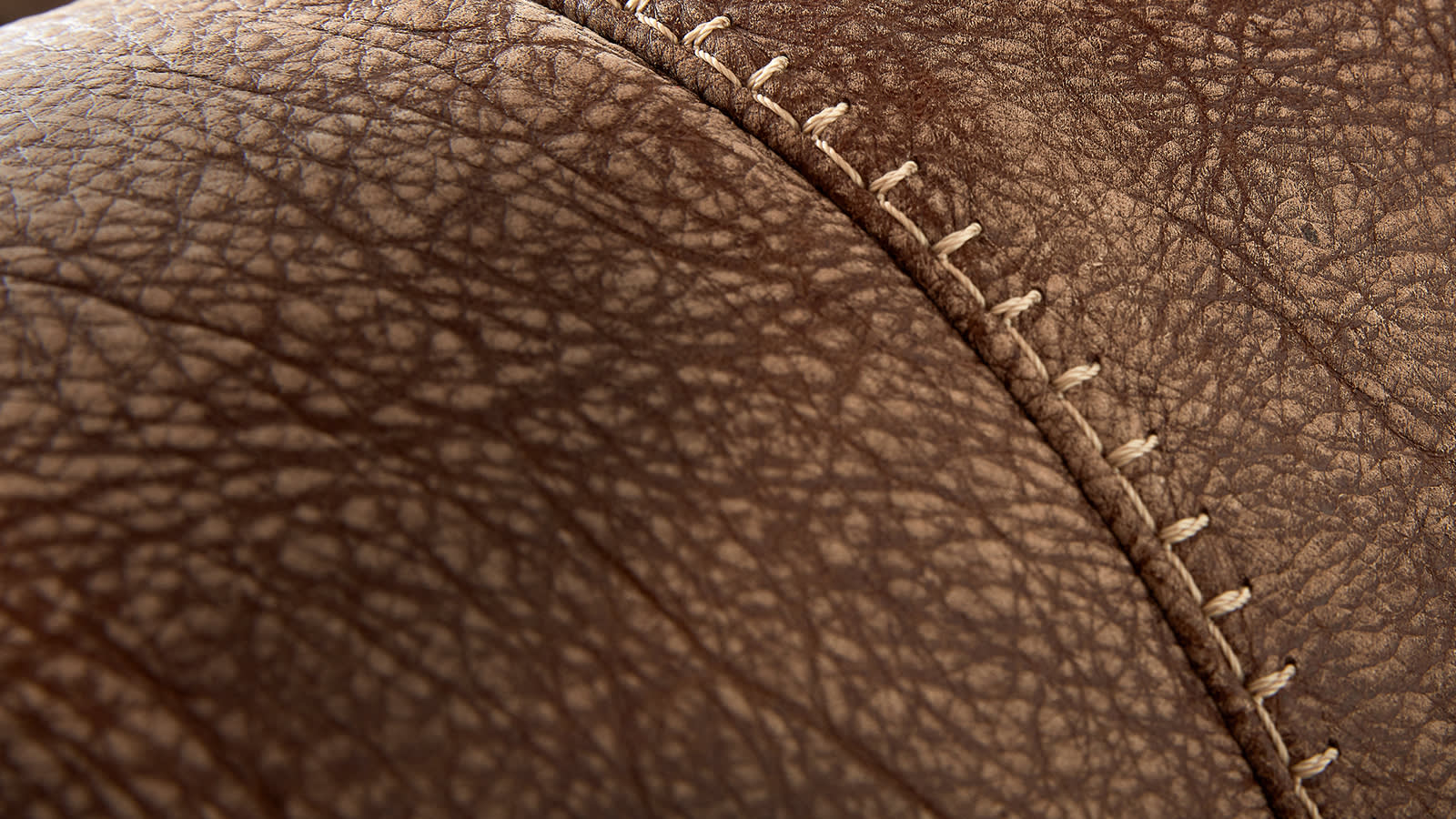 Closeup of brown leather sofa stitching