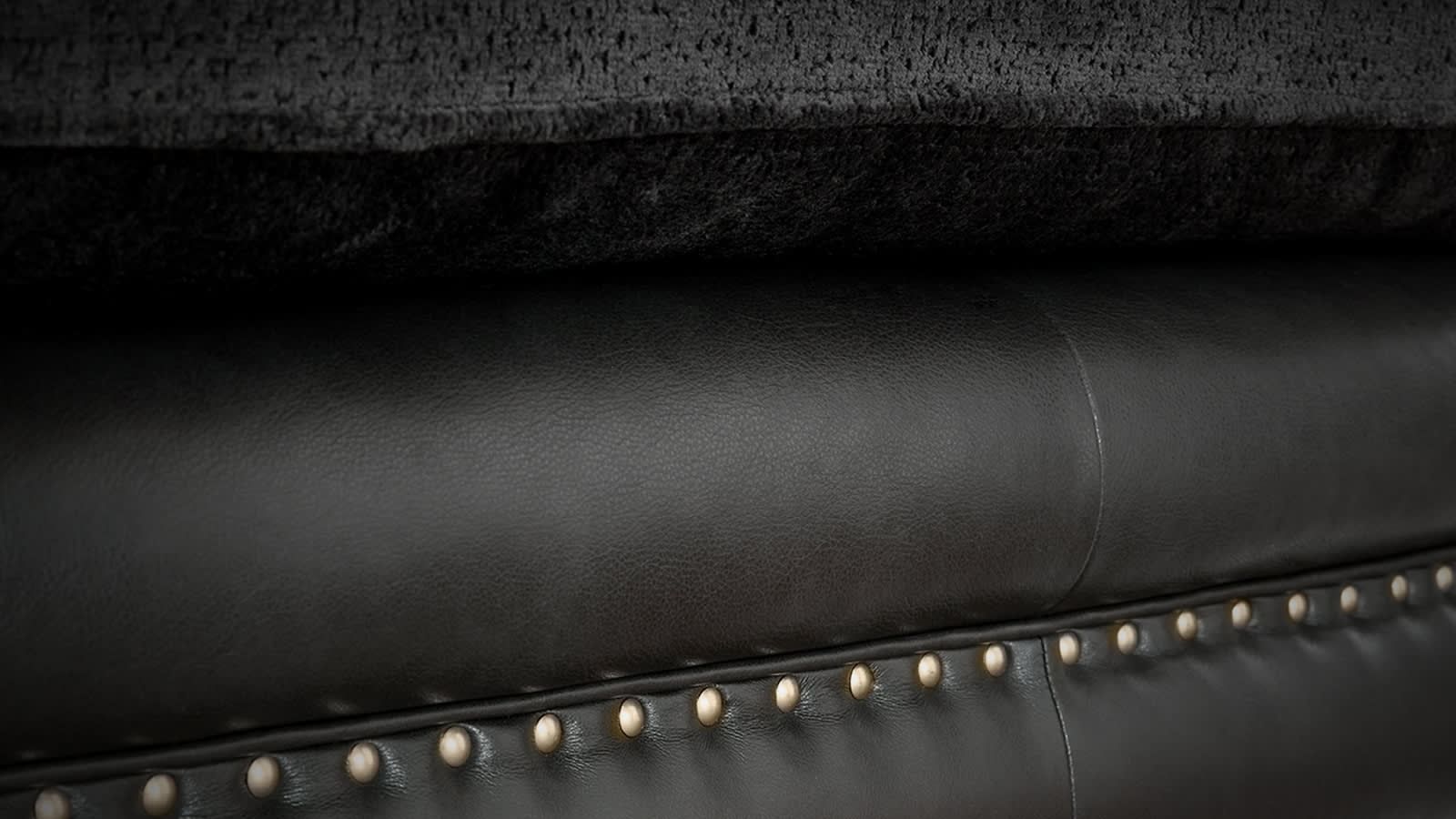 Closeup of black leather sofa studding