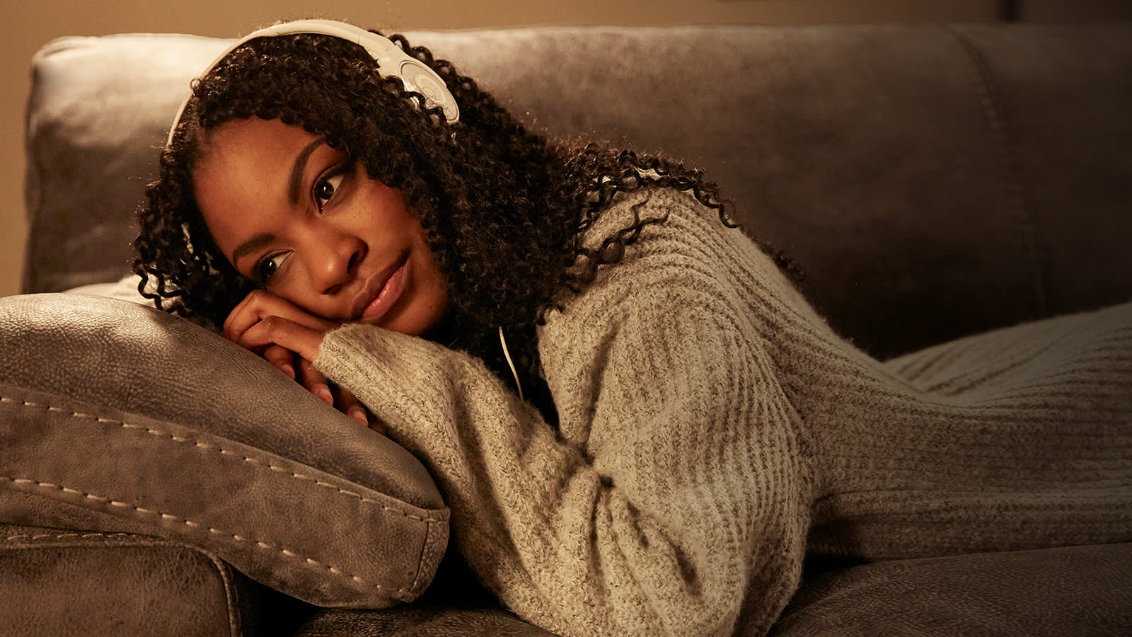 Woman wearing headphones relaxing on a sofa