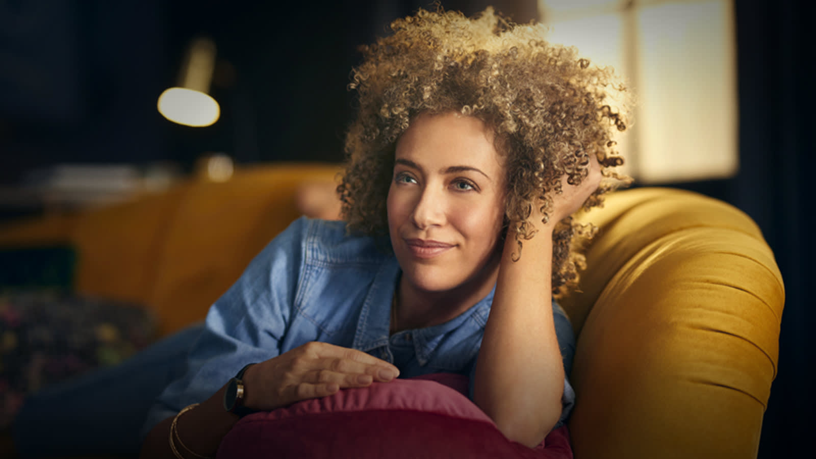 Woman relaxing on velvet Perle sofa range