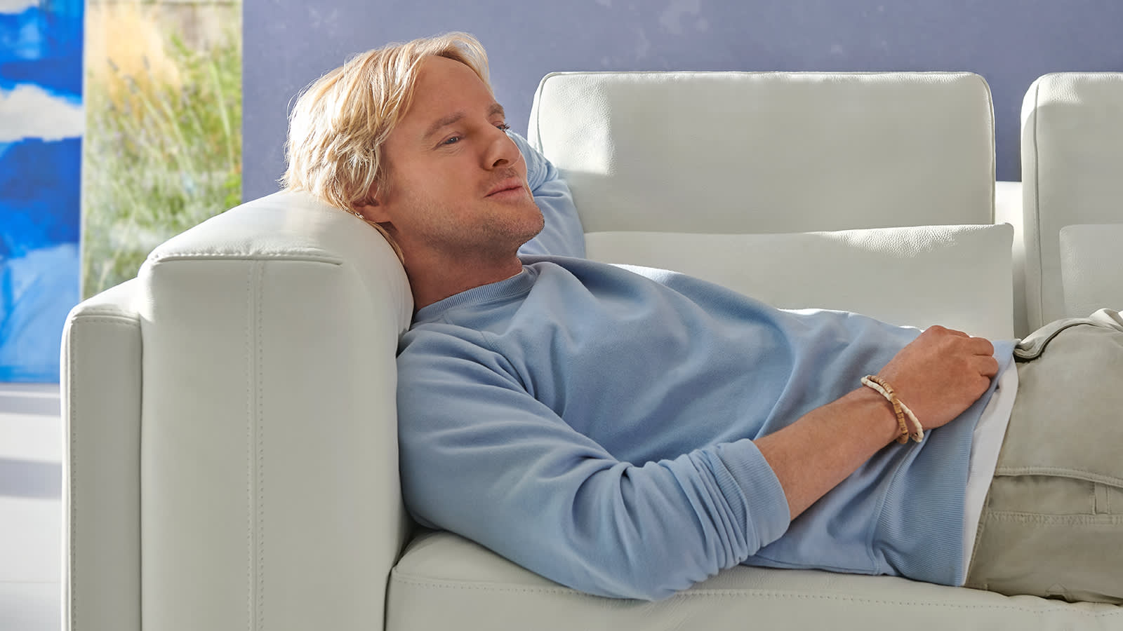 Owen Wilson relaxing on a Sofology Odessy white leather sofa