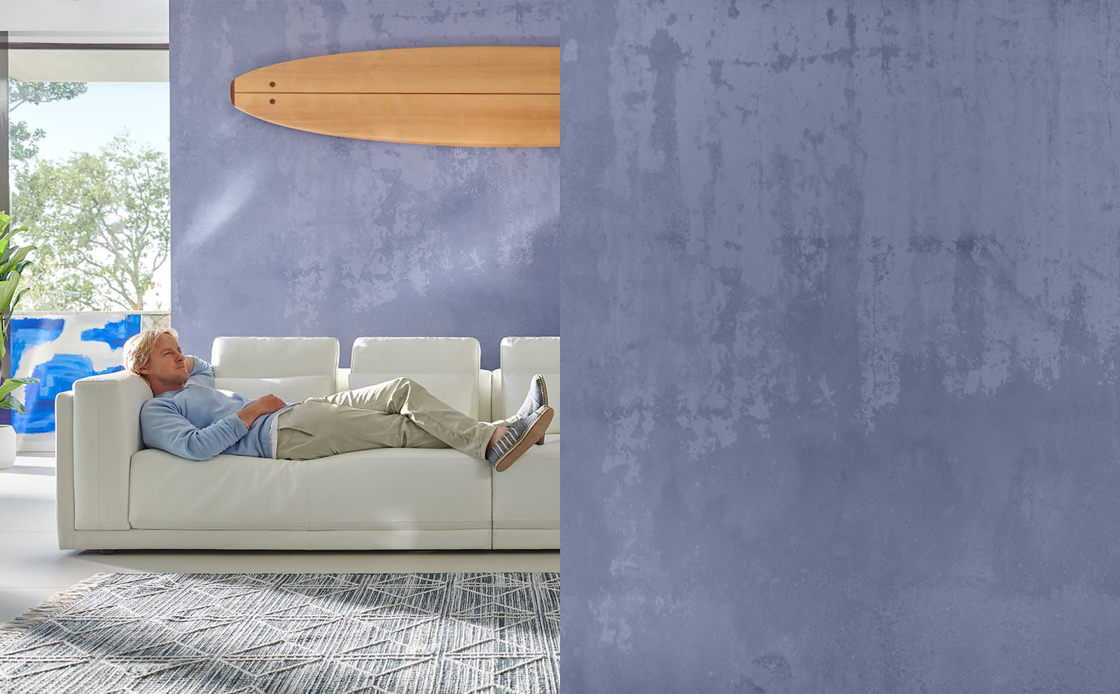 Owen Wilson lying on a Sofology Odessy white leather sofa