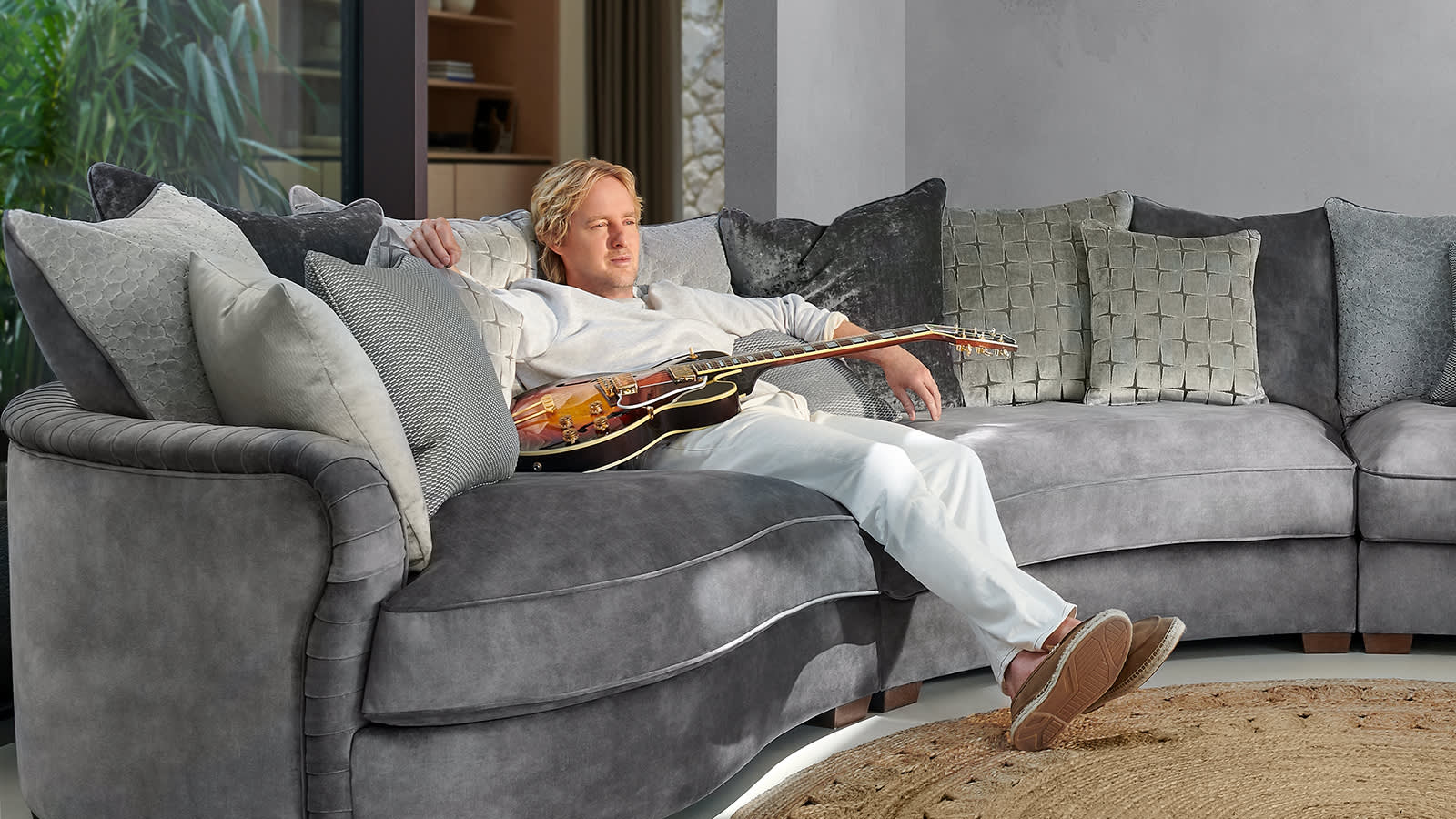 Owen Wilson sitting on the Sofology Palm sofa