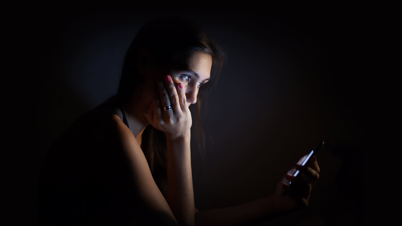Woman in the dark looking at a mobile screen