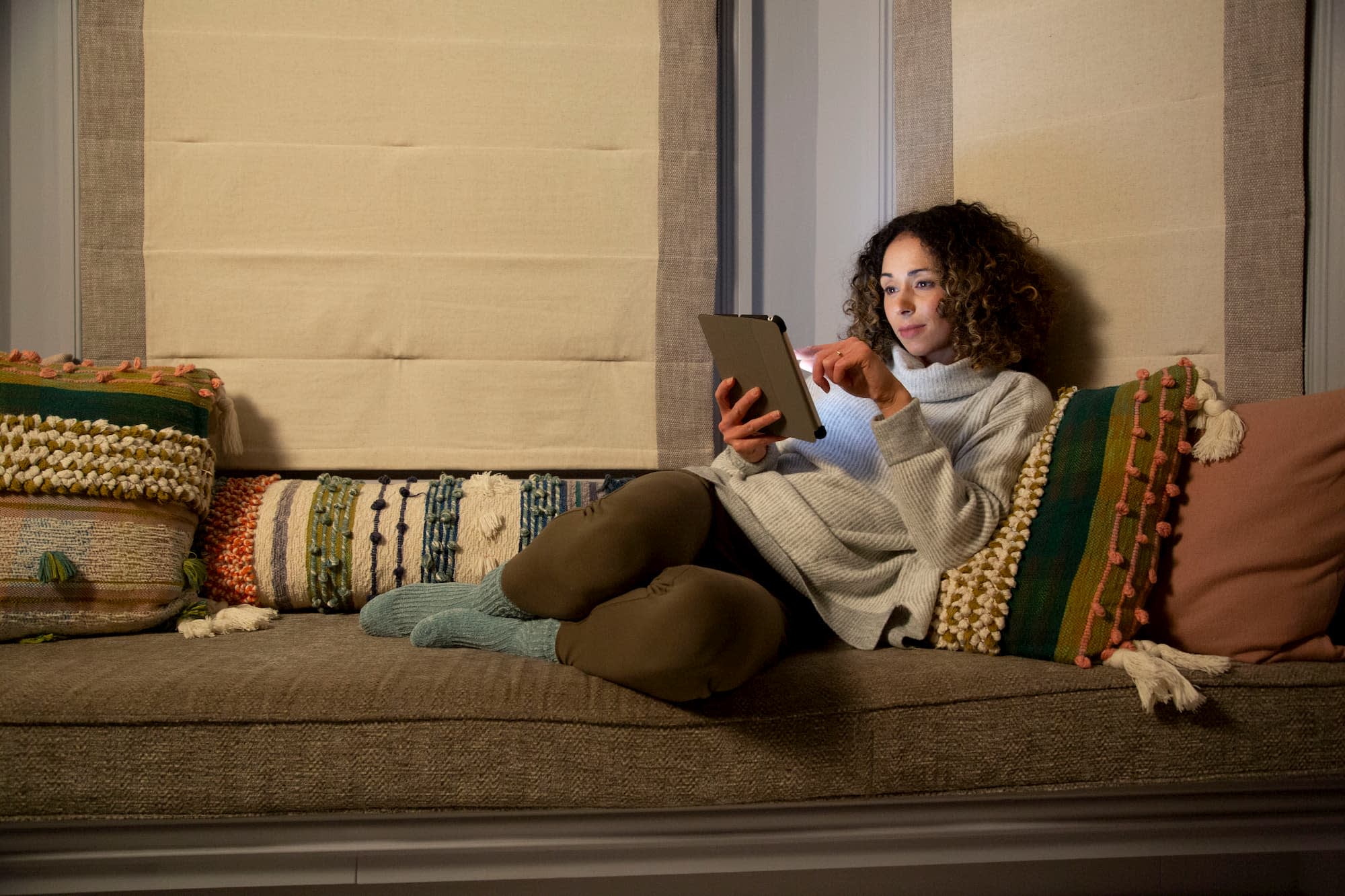 Woman sat on a sofa with a tablet
