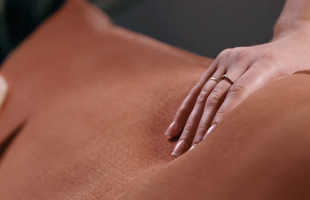 Person grabbing brown sofa pillows