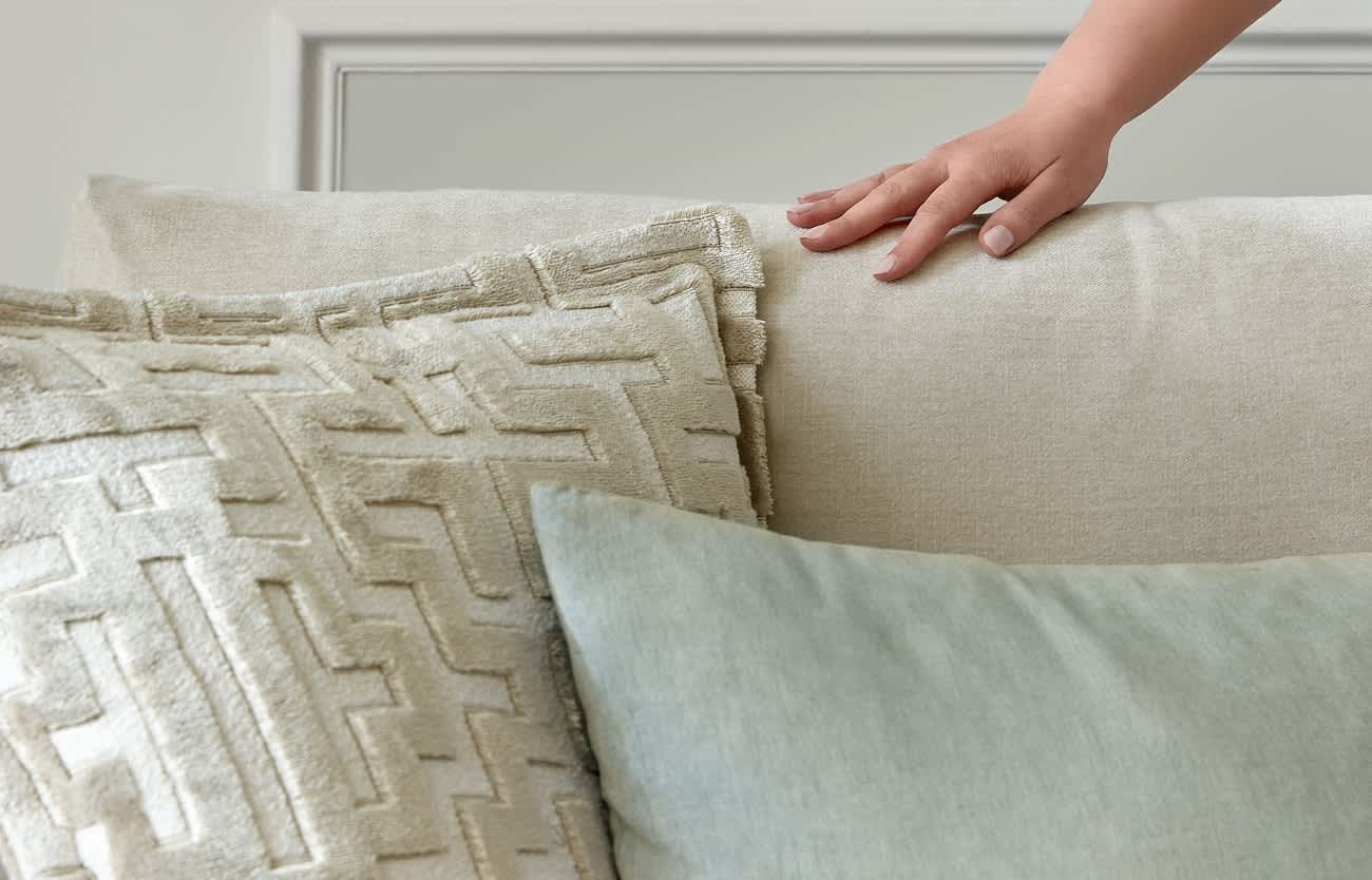 Cream coloured pillows touched by a person