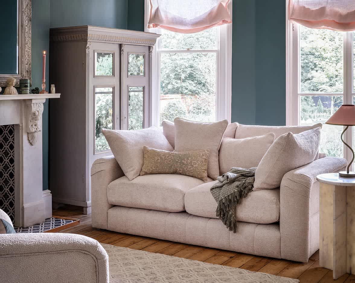 A pink sofa in a brightly lit room.
